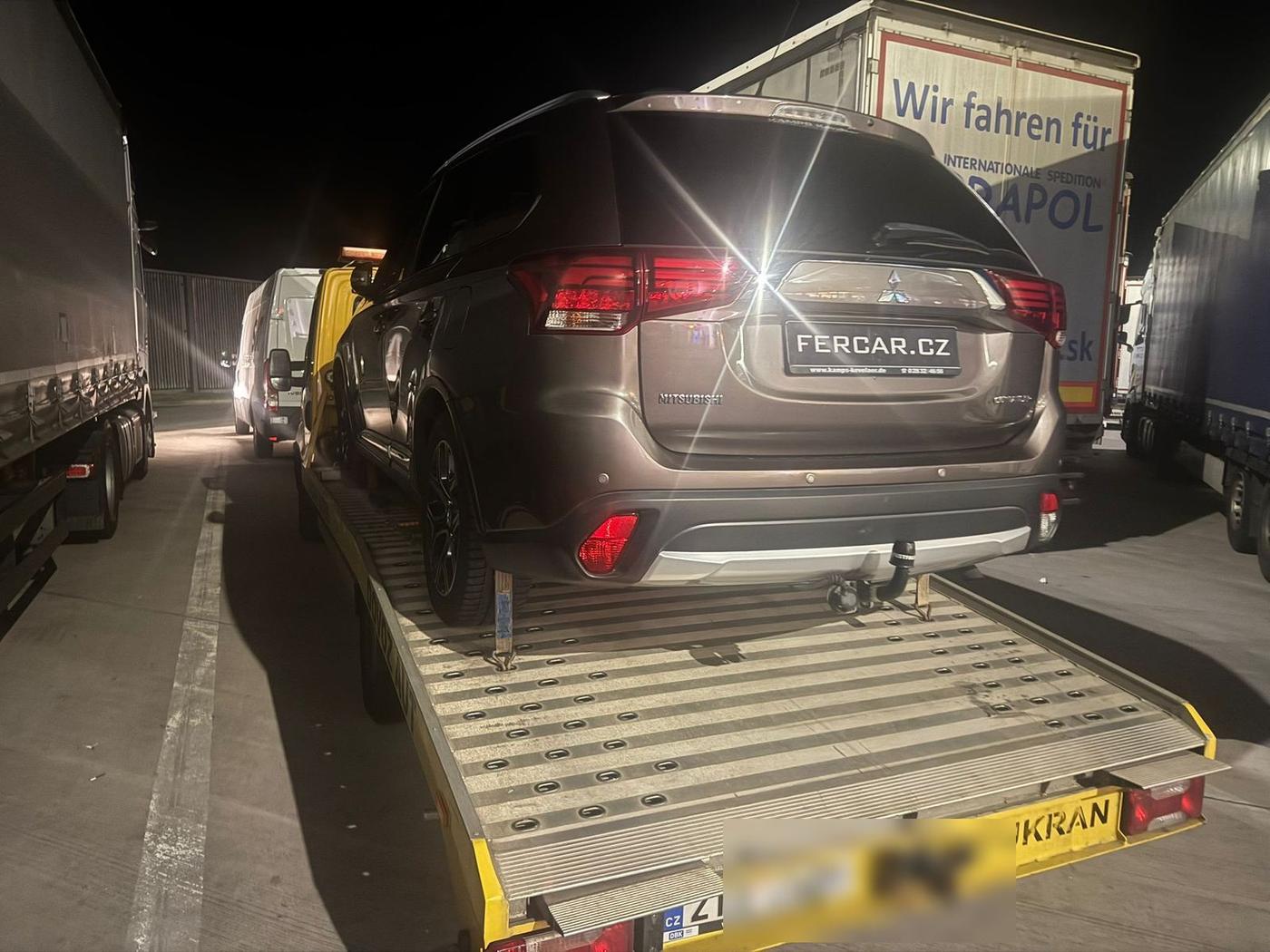 Mitsubishi Outlander naložené na odtahovce při noční přepravě